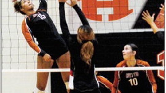 Hutto High School varsity volleyball senior Charlize Williams (15) goes up high for the spike at the net on Sept. 12 during the Lady Hippos’ district match victory at home vs. Harker Heights High School. Photo by Larry Pelchat