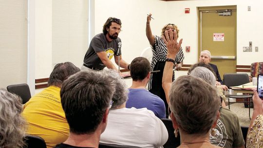 Meeting participants attempt to stop speaker Michael Stark after his allotted three minutes were completed. Photos by Hunter Dworaczyk