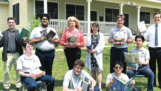 Last year, St. Mary’s Catholic High School faculty and students Gage Garsee, Josh Martinez, Kaedin Hamner, Alex Gauna, Brady Altman, Daniel Vincent, Patrick Heyl, Paula Nemec and John Baker display their new books. File photo