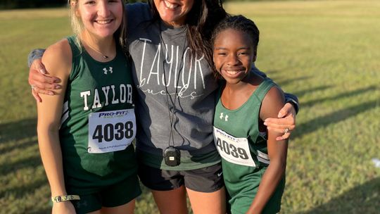 Coach Shelli Cobb stopping to take a picture with Lily Vega (left) and Zari Thompson after a cross country meet earlier this season.      Courtesy Photo    