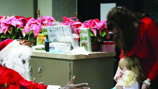 MAKING AN IMPRESSION Santa stops by newspaper office