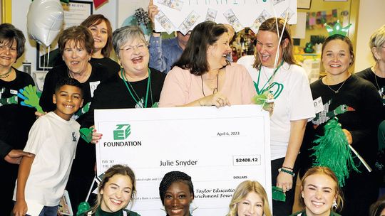 Naomi Pasemann Elementary librarian Julie Snyder is congratulated by TEE Foundation Executive Director Anita Volek and NPE Principal Cynthia Proctor as TEE Foundation board members and THS cheerleaders join the celebration. Photos by Tim Crow