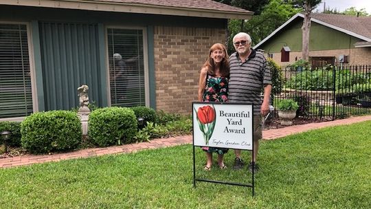 Jane and Clifton Naivar stand in front of their winning yard for the Taylor Garden Club’s Beautiful Yard Award. Courtesy photo