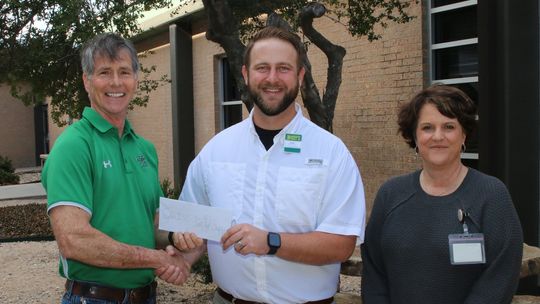 Tyler Volek, manager of McCoy’s Building Supply in Taylor, presents a check for $2,000 to John Matthews, Taylor ISD Family Support Services coordinator. This donation will help provide a variety of programs and services for Taylor families. Photo by Tim Crow