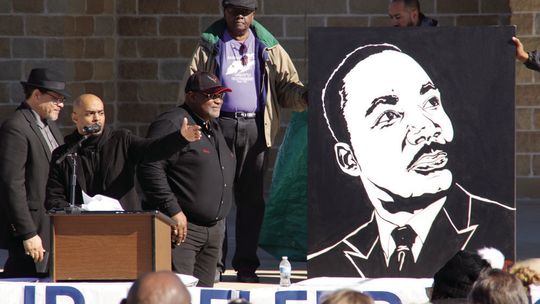 Stephen Michael Johnson (center) talks about the significance of Dr. Martin Luther King Jr. as his painting is unveiled by (from left) Rev. Anthony Watson, Shorty Mitchell and Nelson Alexander. Photos by Jason Hennington