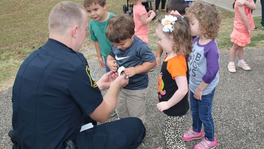 Taylor ISD school resource officer Jacob Loeve visits with students at the district’s child development center about his job in this October 2019 photo.  Photo by Tim Crow