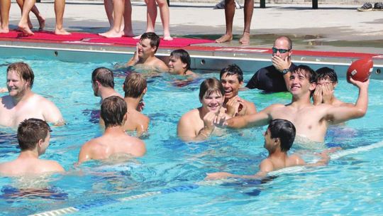 Thrall ISD players and coaches beat the heat by tossing the ball around in Murphy Park pool in Taylor in this August 2015 photo. File photo