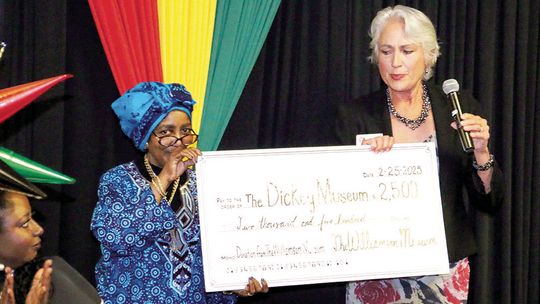 Dickey Museum Board President Jennifer Harris (left) accepts a $2,500 check from Nancy Hill of the Williamson Museum for the restoration of the Dickey Museum &amp; Multipurpose Center. Photo by Jason Hennington