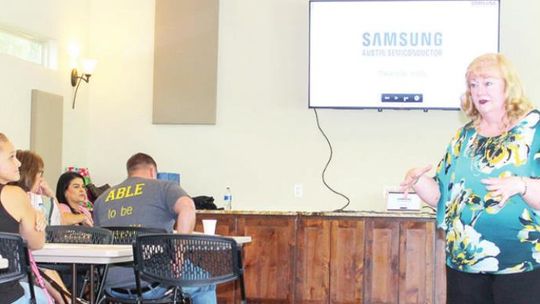 Michele Glaze, Samsung Austin Semiconductor director of corporate public affairs and community liaison, talks with representatives of area nonprofits during an information session at the 5th and Vance Events center in Taylor Aug. 4. Photo by Fernando Castro