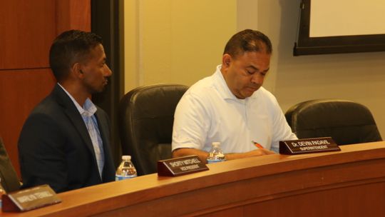 Superintendent Devin Padavil and board president Marco Ortiz discuss items during a special called meeting of the Taylor ISD board of trustees in Taylor May 31. Photo by Jason Hennington