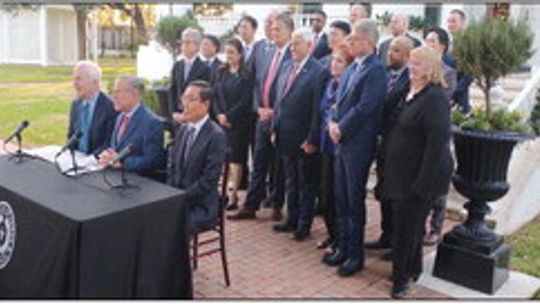 Gov. Greg Abbott (sitting, centered) begins a press conference to announce the Samsung investment in Taylor at the Governor’s Mansion in Austin Nov. 23, 2021. Photo by Jason Hennington