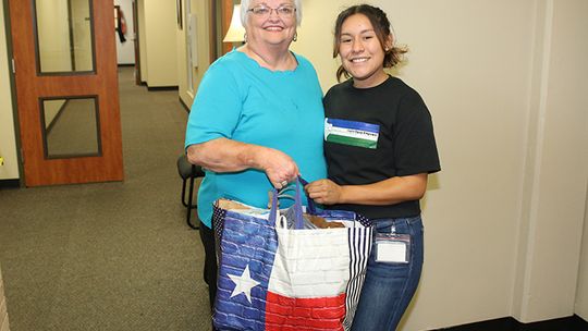 Taylor Area Businesswomen President Charlotte Albert presents a donation of school supplies to Taylor ISD district receptionist Kassandra Salinas. The supplies will be distributed to benefit students across the district. Photo by Tim Crow