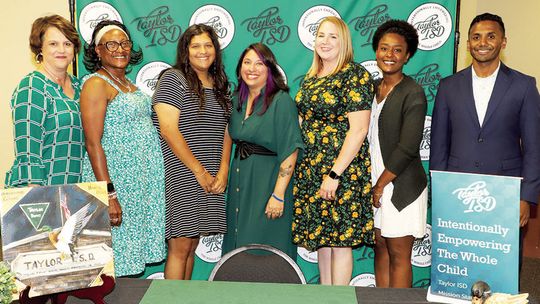 Taylor ISD Superintendent Devin Padavil and Assistant Superintendent Jennifer Patschke congratulate five of the six paraprofessionals elevating their careers to teaching positions for next school year. At the event were (from left), Patschke, Eliza Ackerman, Kylie Oglesby, Robyn Fernandez,...