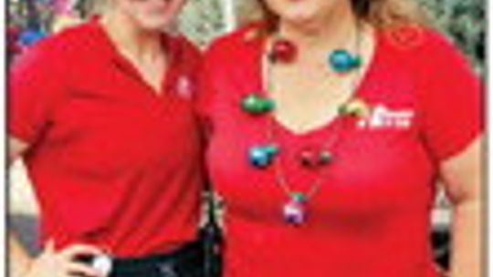 Hutto city employees Taylor Arrington and Allison Strupeck help fairgoers get in the holiday spirit at the city’s information booth.