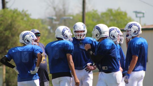 St. Mary's Catholic School varsity football huddles around coach Rick Cobia during a 2022 preseason scrimmage. Photos by Evan Hale