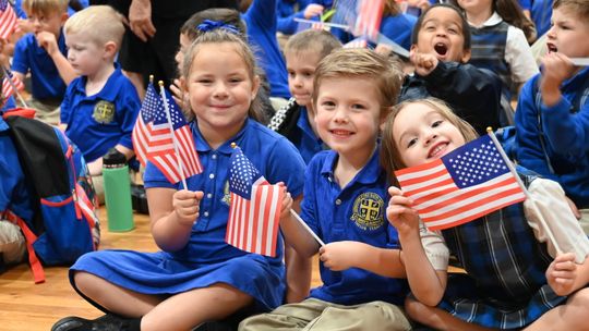 St. Mary’s Kindergarten students Stormy Lynch, James Friesenhahn and Amelia Hammans enjoy the Veteran’s Day ceremony. Courtesy photo