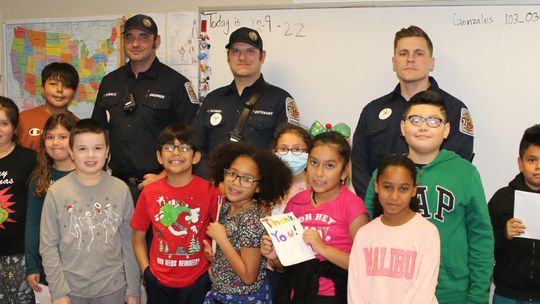 Students in Teresa Gonzales’ third grade class at Naomi Pasemann Elementary present the Taylor Fire Department with a donation for the Red Santa Program. The money was used to purchase food and presents for several Taylor Families. Photo by Tim Crow