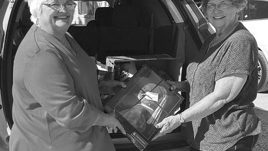 Taylor Area Businesswomen President Charlotte Albert unloads Bingo gifts to Senior Citizens Coordinator Dorothy Fischer.