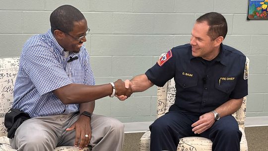 Taylor Fire Chief Daniel Baum (right) is welcomed with a handshake by Area Editor Jason Hennington. Photo by Grace Horvath