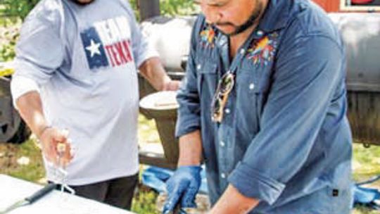 At last year’s International Barbecue Cook-Off, brothers Geraldo and Fernando Reyes slice some brisket to submit for judging. Photo by Fernando Castro