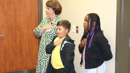 Pledge Leaders Paxton Valdez and C’Anne Adelle Campise, students at Naomi Pasemann Elementary School, open the October Taylor school board meeting by leading the pledge of allegiance. Accompanying them is Jennifer Patschke, Executive Director of Elementary Schools and Special Programs.