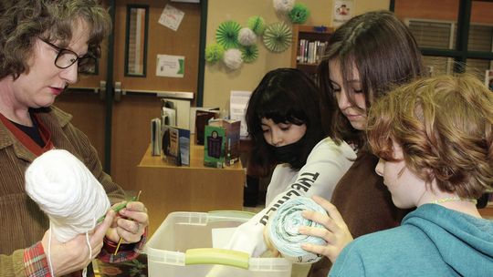 Taylor Middle School Librarian Renee De Hoyos assists crochet club members with selecting yarn for their projects.