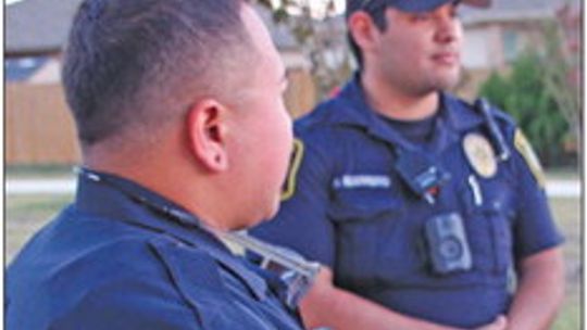 Patrol officers Michael Mcintire (left) and Moses Guerrero chat Oct. 4 at the National Night Out block party for the Avery Glen subdivision.