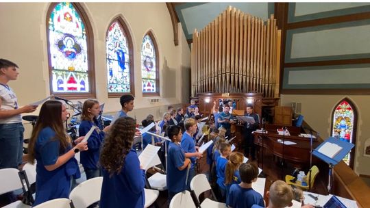 Students and faculty review the lyrics of The Bells of St. Mary’s before recording. Courtesy photos