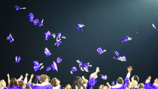 Graduates toss their caps after the ceremony. Photo by Edie Zuvanich