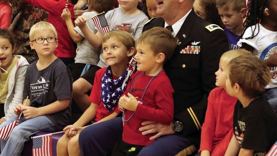 Students sit with Wesley West during the Veteran’s Day celebration at Thrall ISD.