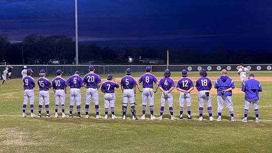 Thrall Tigers varsity baseball team standing shoulder to shoulder as the National Anthem plays before their first game of the season.