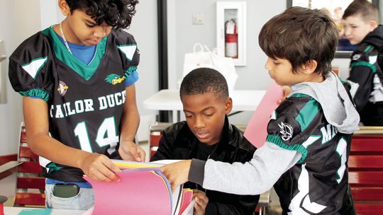 (From left) Dimitri Burt, 10, gathers supplies Dec. 20 with Clavon Barnes, 10, and Davian Meadows, 10 at Taylor CAARTS Station. Photos by Nicole Lessin