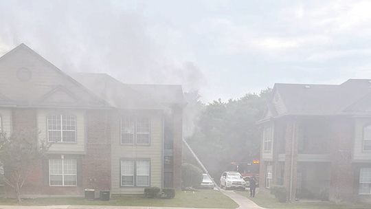 The lower floor of Building 3 sustained extensive water damage during a fire at the Burnett Place Apartments Monday. Firefighters using a ladder rescued two residents and no injuries were reported. Courtesy photo