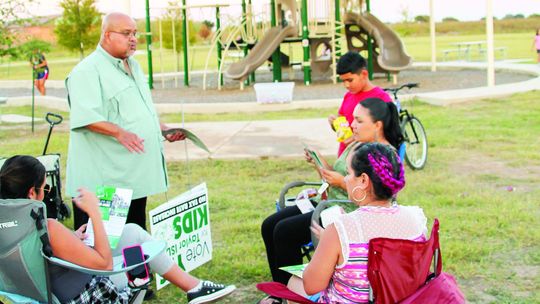 Former Taylor Independent School District trustee Thomas Martinez, a member of the Citizens for Taylor ISD Political Action Committee, talks with parents about the bond issue Oct. 4 at a celebration for National Night Out at the Avery Glen subdivision. Residents used grassroots organizing...