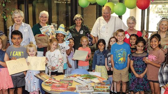 Retired teachers are greeted by kindergarten students as they arrive at T. H. Johnson Elementary to read to classes. Photos by Tim Crow