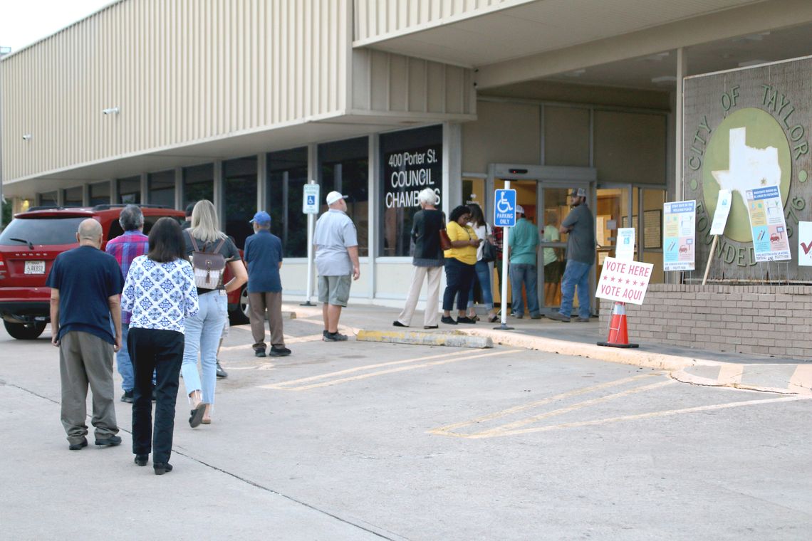 Voters stand outside at Taylor City Hall Tuesday evening waiting to cast their votes. Photo by Jason Hennington