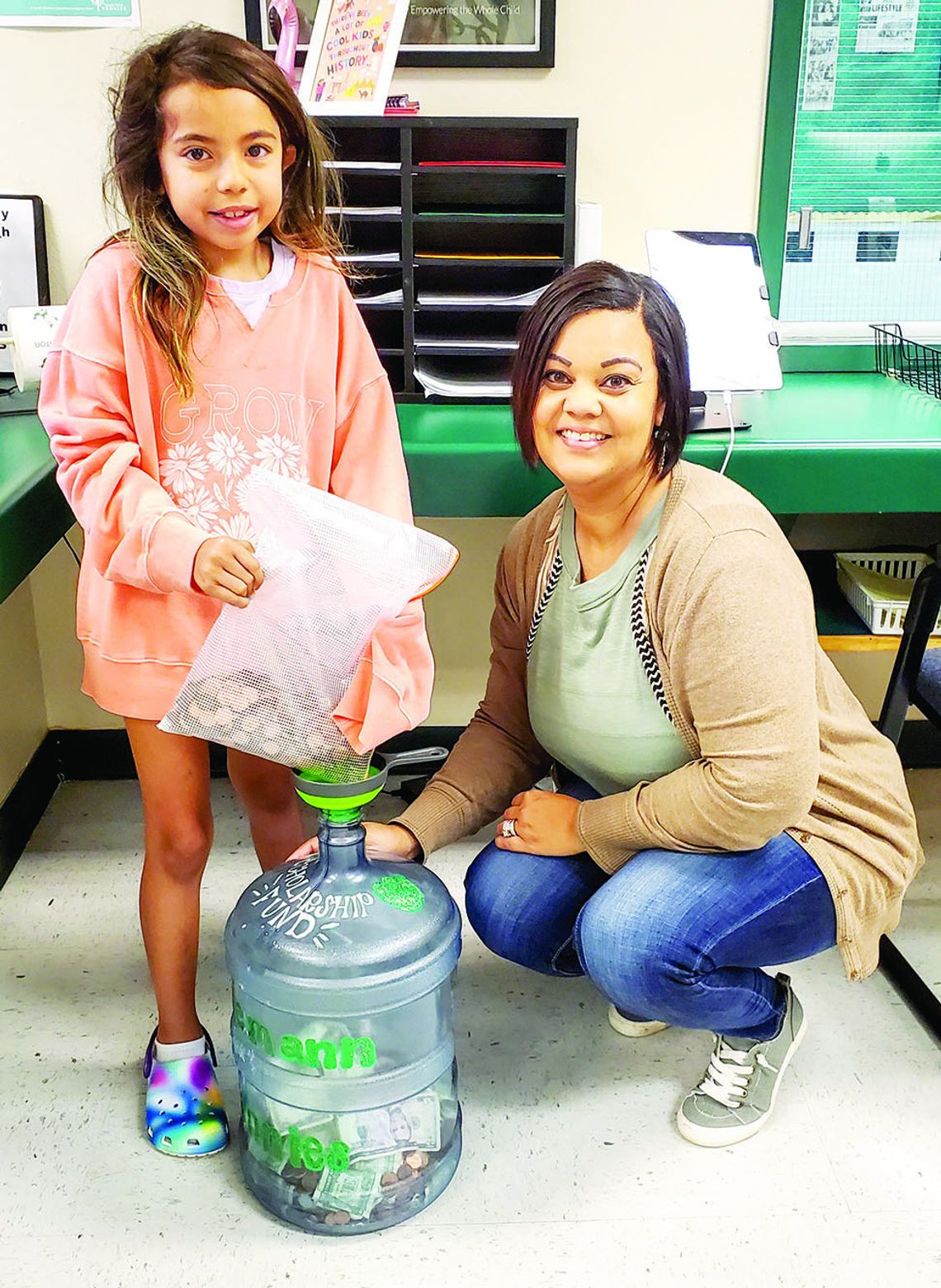 Naomi Pasemann Elementary student, Jayda Leal, deposits her donation to the Pasemann Pennies fund with the assistance of Principal Felicia Gibson. Courtesy photo