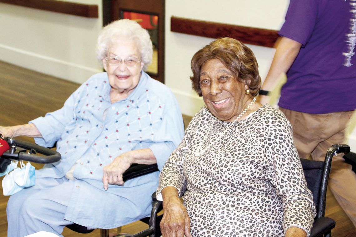 Lessie Givens (right) enjoys visiting with other residents at the S.P.J.S.T. Nursing Home before a presentation in her honor. Photos by Jason Hennington