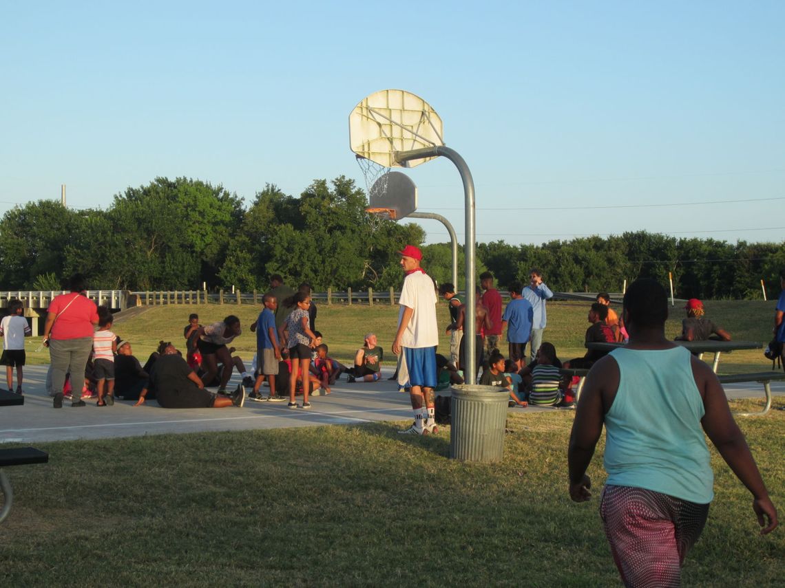 Children of all ages come together to listen to a guest speaker at Midnight Basketball in Fannie Robinson Park in this 2016 photo. File photo