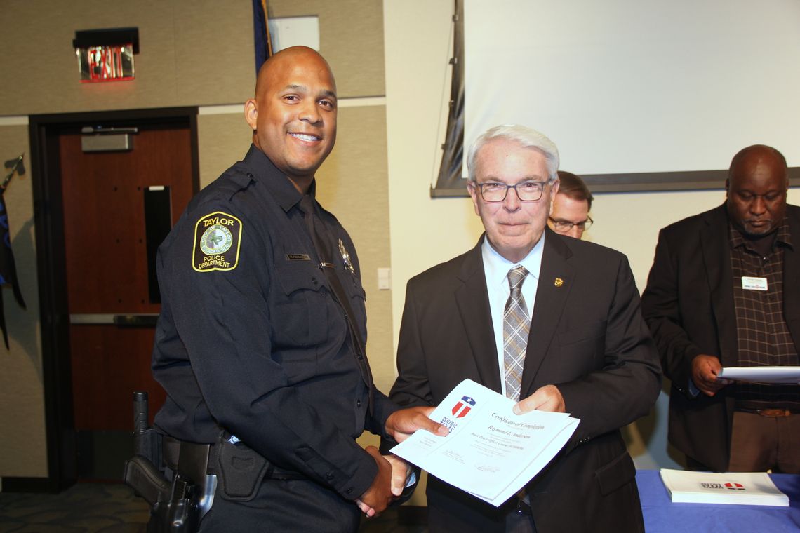 Raymond Anderson, of the Taylor Police Department, receives congratulations from Jim Yeonopolus, Central Texas College chancellor, during the Central Texas College Police Academy graduation ceremony earlier this summer.   Courtesy photo