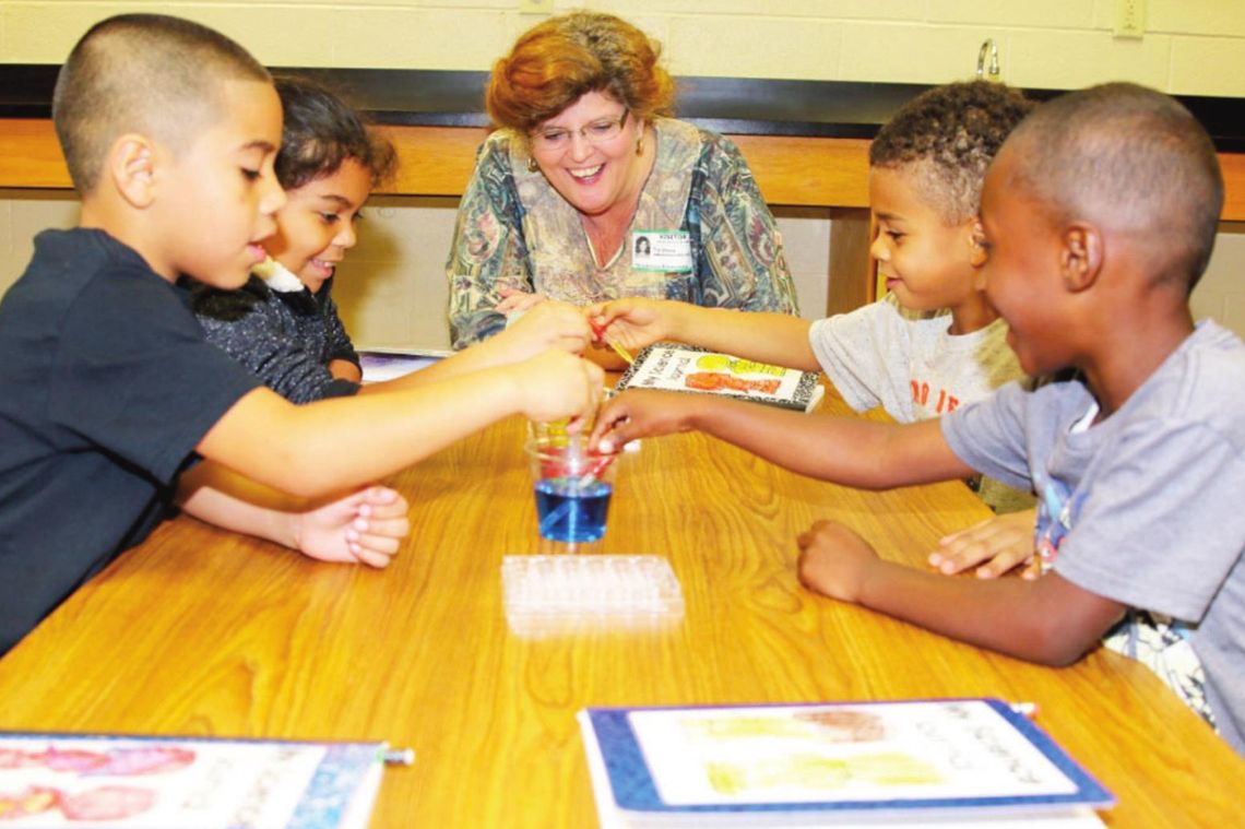 Greater Taylor Chamber of Commerce President Tia Rae Stone joins a group of kindergarteners for a fun science experiment as part of the Taylor ISD Ambassador program in 2016. Photos by Tim Crow