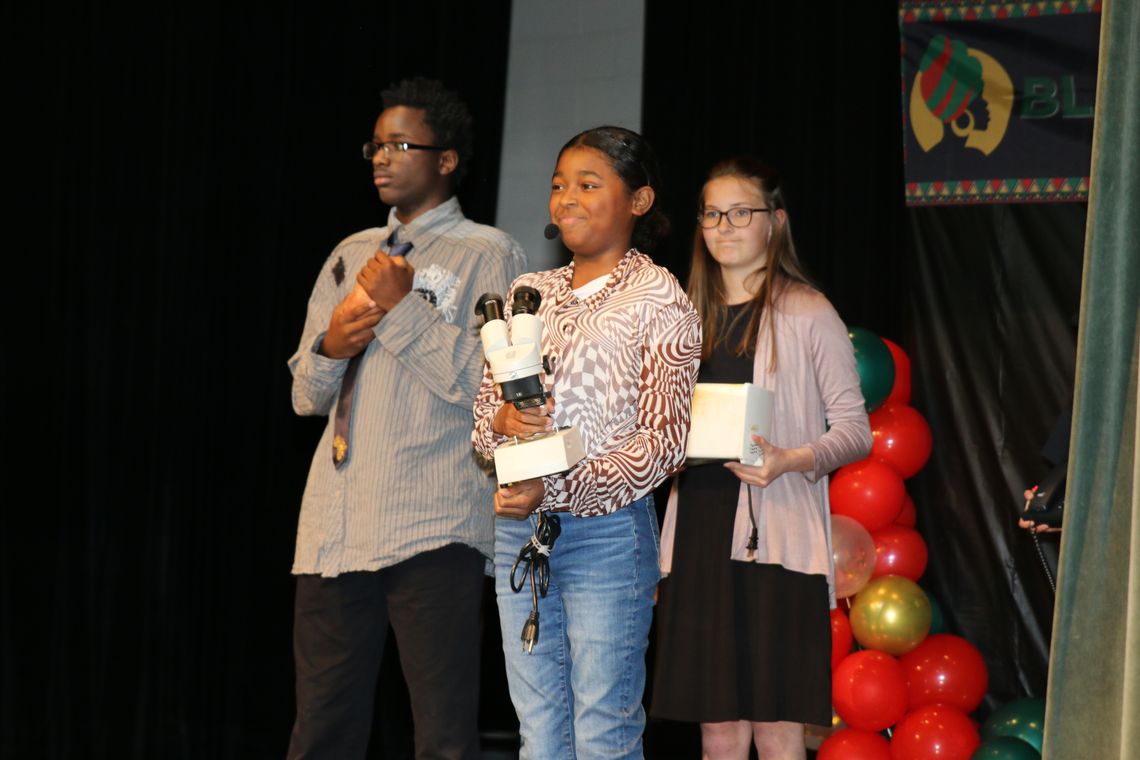 Billie Harrison, Ce’Delia Moore and MacKenzie Maybin recognize the contributions of George Washington Carver, Patricia Bath and Ruane Jeter at the TMS Black History program. Photo by Tim Crow