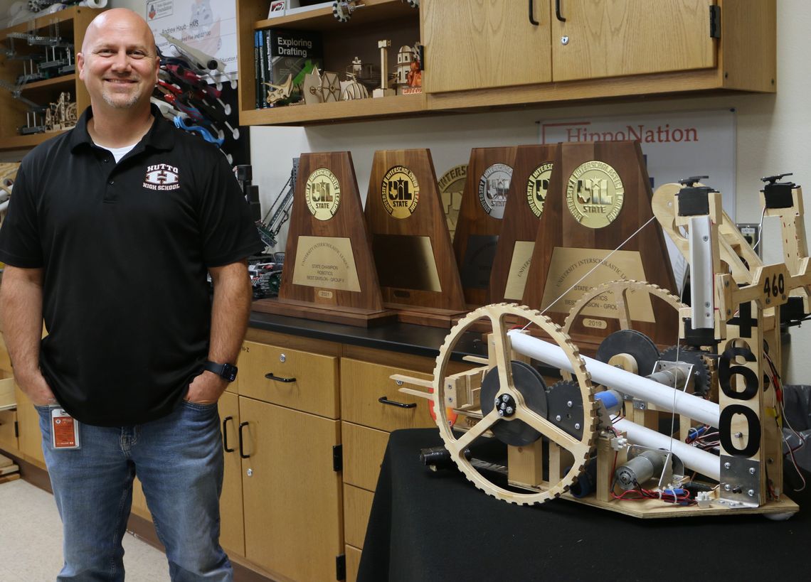 Lead Robotics Instructor Andrew Haub, coach of the Hutto HS robotics team known as RoboCo X, shows off the team trophies next to one of the winning robotics projects. Haub’s team has won four of the last five UIL state championships. Photos by Edie Zuvanich