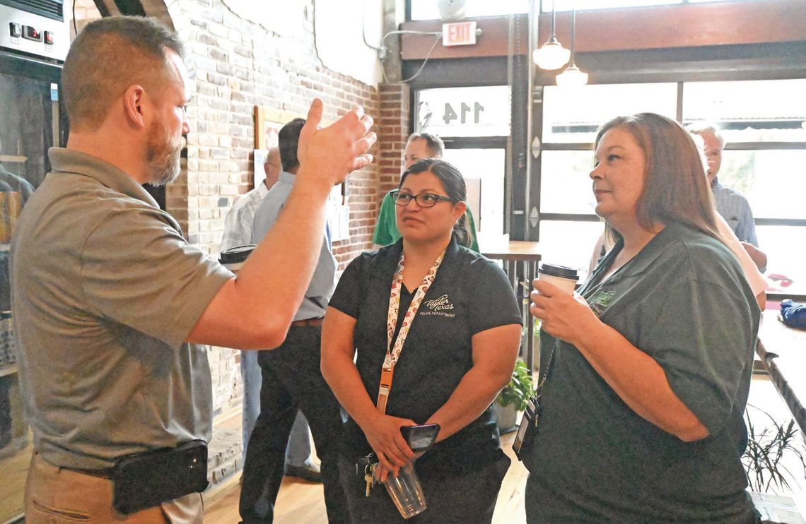 City Manager Brian LaBorde talks with Taylor Police Department Support Services Administrator Claudia Parisella, center, and Communications Supervisor Theresa Briones during Coffee with a Cop on May 10 at Good Strangers. Photo by Kendra Maness