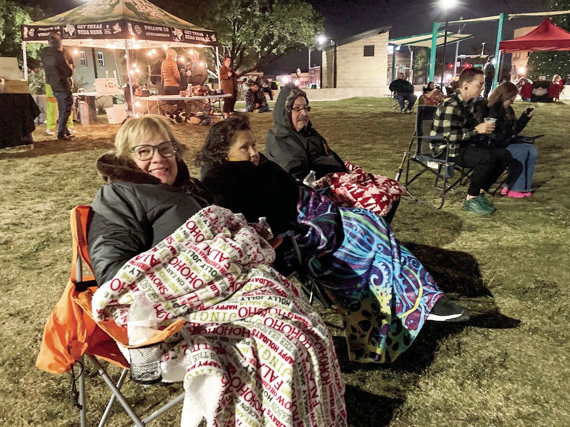 (From left) Dora Gomez, Estella De La Rosa and Joe De La Rosa keep warm as they enjoy the musical stylings of R &amp; B band Honey Made Nov. 17 at Heritage Square Park. Photos by Nicole Lessin