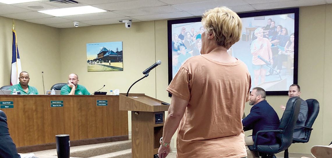 Stacy Stork, a member of a citizens compensation committee, protests the City Council’s split vote to increase their own pay to $1,000 per month and $1,500 for the mayor at the regular meeting July 27. Photo by Nicole Lessin