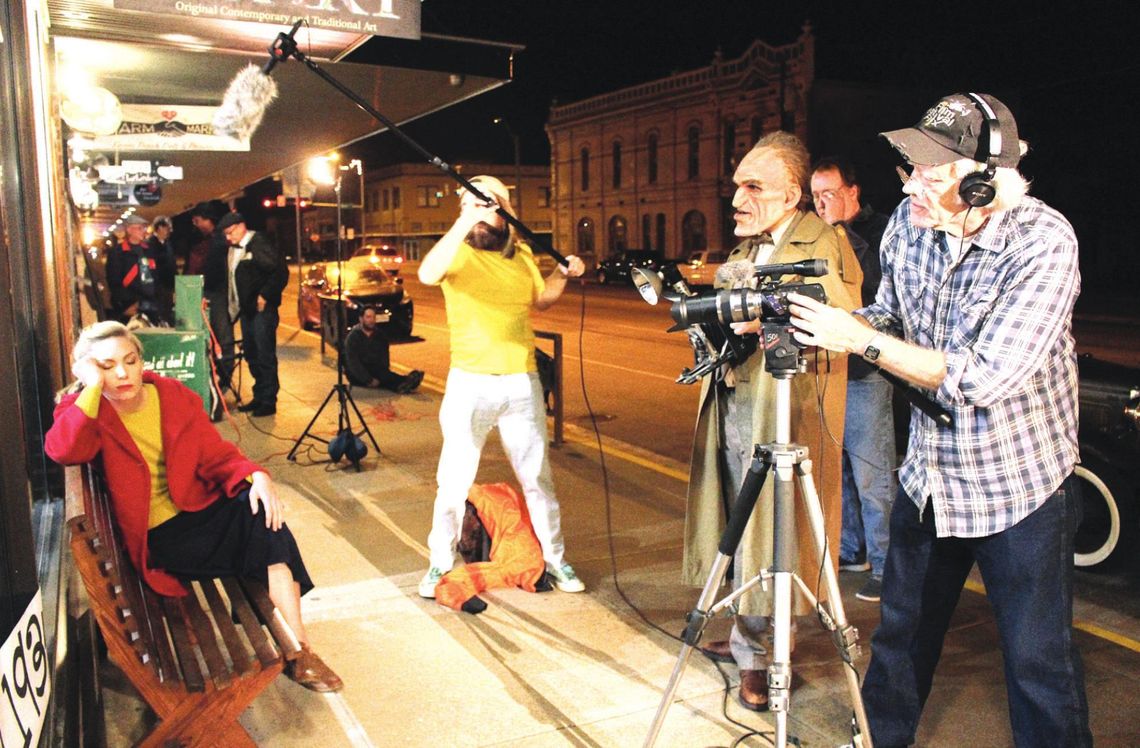 A scene from “Rondo and Bob” is shot outside 120Art in downtown Taylor. Pictured is Kirk Hunter on camera, Joseph Middleton as Rondo Hatton, and Joe O’Connell directing. Holding the boom microphone is Geo Rollier. Seated to the left is Kelsey Pribilski as Mae Hatton. Photo by Paul Smith