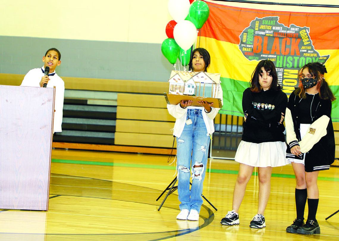 Rodolphe Rochez honors Dr. James L. Dickey with a tribute to his life and career while classmates display a model of Dr. Dickey’s home in Taylor. See an additional photo from the event on page 2 E-edition. Photos by Tim Crow