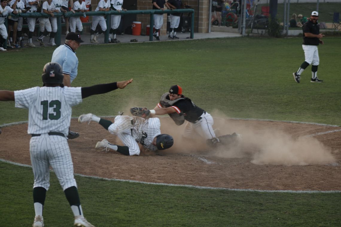 Ashton Vega stirs up the dust as he crosses home plate in Friday night’s bi-district win for the Ducks over Smithville.