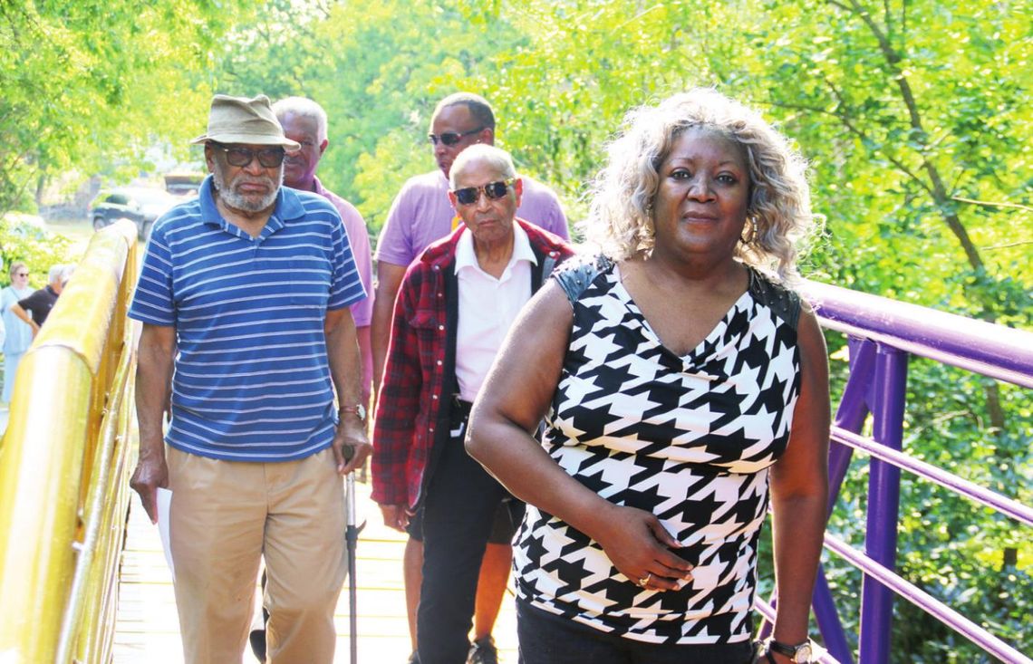 Doris Corely leads other former O.L. Price students Raymond White Jr., Ernest Rector, Rev. James Davis and current Mayor Pro Tem Gerald Anderson across the Dickey bridge June 27 in Taylor. Photos by Jason Hennington